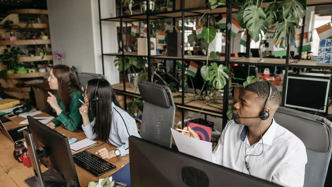 Employees working at computers in a busy office